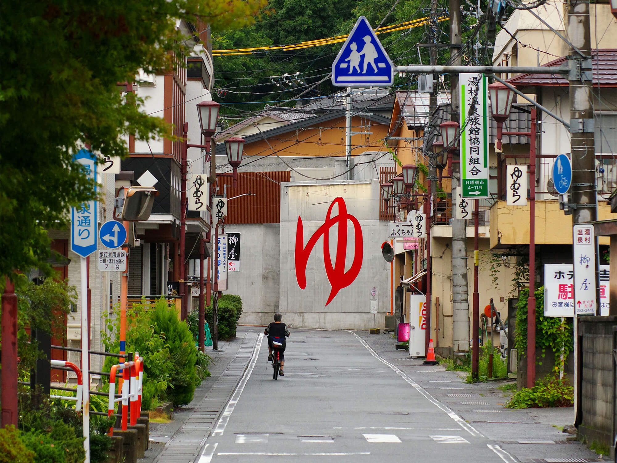 突き当たりに「ゆ」と大きく書かれた看板が見える、湯村温泉郷のレトロな街並みと道路